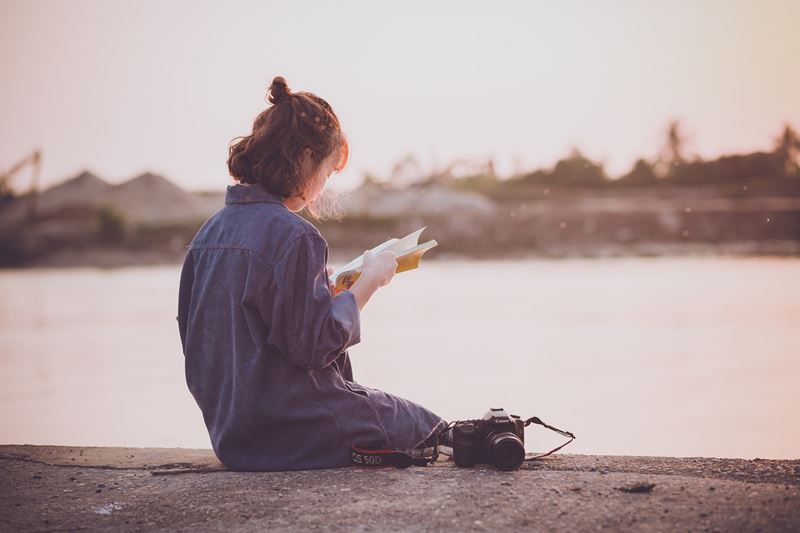 海岸で本を読む女性